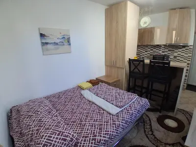 a small bedroom with a bed and a kitchen at Studio19 in Podgorica
