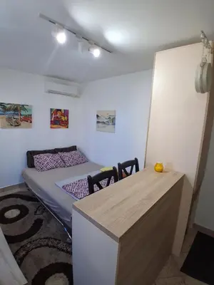 a bedroom with a bed and a desk with chairs at Studio19 in Podgorica