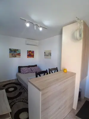 a room with a bed and a table with chairs at Studio19 in Podgorica