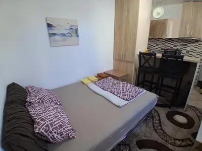 a small room with a bed and a kitchen at Studio19 in Podgorica