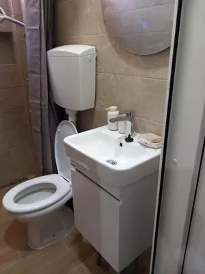a bathroom with a white toilet and a sink at Studio19 in Podgorica
