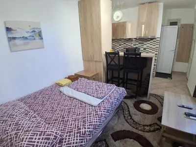 a small room with a bed and a kitchen at Studio19 in Podgorica