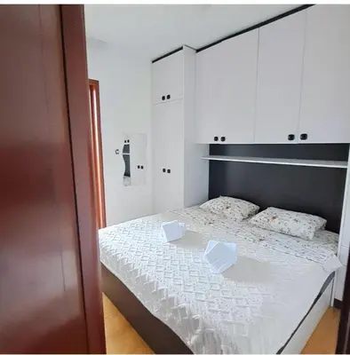 a bedroom with a white bed with two boxes on it at Apartman Podgorica - Pobrezje in Podgorica