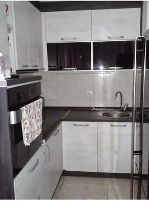 a kitchen with white cabinets and a sink at Apartman Podgorica - Pobrezje in Podgorica