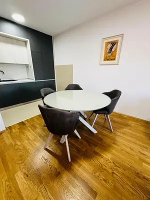 a dining room with a white table and chairs at Royal Stay Podgorica - Princess Apartment in Podgorica
