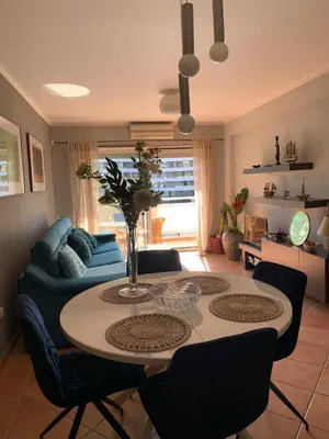 a living room with a table and a blue couch at Appartement centre avec garage privé in Budva