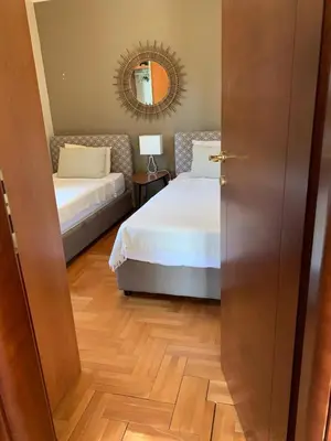 a bedroom with two beds and a mirror at Appartement centre avec garage privé in Budva