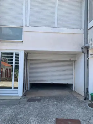 a garage with a roll up door next to a building at Appartement centre avec garage privé in Budva