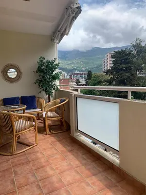 a balcony with chairs and a large blank billboard at Appartement centre avec garage privé in Budva