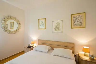 a bedroom with a white bed and a mirror at Apartment Srdanovic in Budva