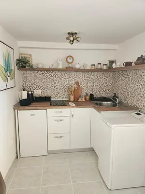a kitchen with white cabinets and a sink at Apartment Srdanovic in Budva