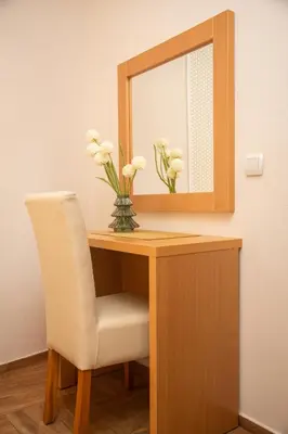 a desk with a mirror and a white chair at Apartments Bogojevic in Ulcinj