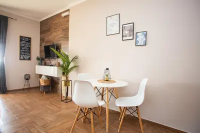 a dining room with a table and white chairs at Apartments Bogojevic in Ulcinj