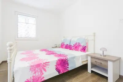 a bedroom with a bed with pink and purple pillows at Apartment Mia in Sveti Stefan