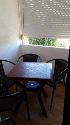 a table and chairs in a room with a window at Apartments Music in Sutomore