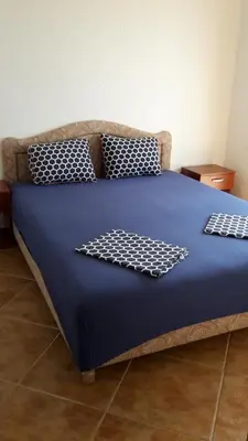 a blue bed with black and white pillows on it at Apartments Music in Sutomore