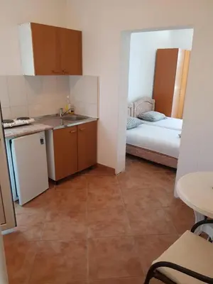 a small kitchen with a sink and a bed at Apartments Music in Sutomore