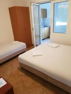 a bedroom with two beds and a mirror at Apartments Music in Sutomore
