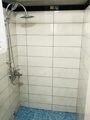 a bathroom with a shower with white tile walls at Apartments Sunpoint in Ulcinj