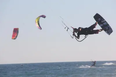 a man riding a kite in the ocean at Apartments Sunpoint in Ulcinj