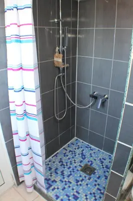 a bathroom with a shower with blue and white tiles at Apartments Sunpoint in Ulcinj