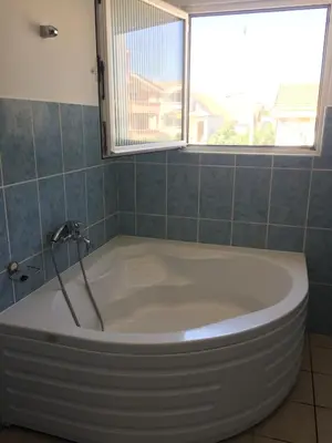 a bath tub in a bathroom with a window at Apartments Sunpoint in Ulcinj