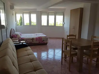 a living room with a couch and a table and a bed at Guest House Dragomir in Sutomore