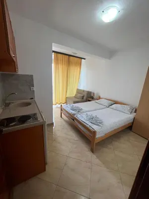 a bedroom with a bed and a kitchen with a stove at Sand and Sea Apartments in Ulcinj
