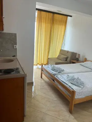 a bedroom with a bed and a couch and a stove at Sand and Sea Apartments in Ulcinj