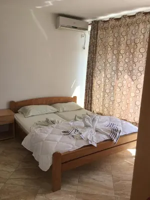 a bed sitting in a bedroom with a curtain at Sand and Sea Apartments in Ulcinj