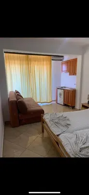 a bedroom with a bed and a couch and a kitchen at Sand and Sea Apartments in Ulcinj