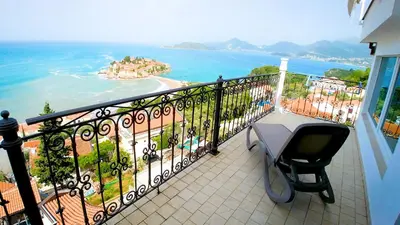 a balcony with a table and a view of the ocean at Villa Edelweiss in Sveti Stefan