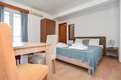 a bedroom with a bed and a desk and a table at Apartments Milos Kaladjurdjevic in Budva