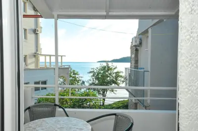 a balcony with a table and chairs and a view of the ocean at Apartments Milos Kaladjurdjevic in Budva