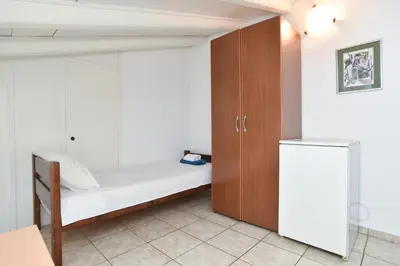 a small bedroom with a bed and a cupboard at Apartments Milos Kaladjurdjevic in Budva