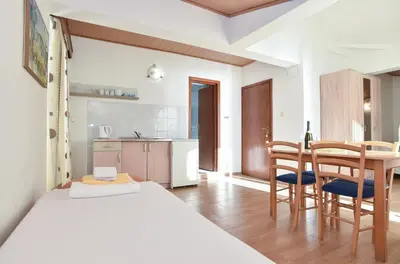 a bedroom with a bed and a table and chairs at Apartments Milos Kaladjurdjevic in Budva