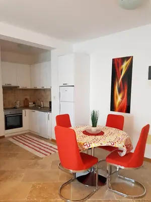 a kitchen with a table and red chairs in a room at Luxury Apartments Trend in Budva
