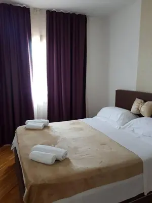 a bedroom with a large bed with two towels on it at Luxury Apartments Trend in Budva