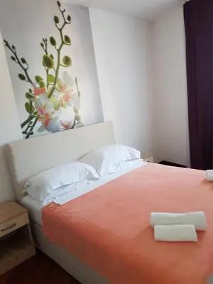 a bedroom with a bed with an orange blanket at Luxury Apartments Trend in Budva
