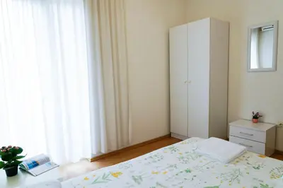 a bedroom with a bed and a white cabinet at Guest House Heart of Budva in Budva