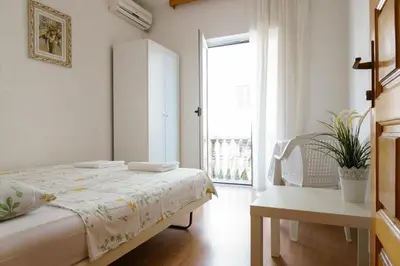 a white bedroom with a bed and a window at Guest House Heart of Budva in Budva