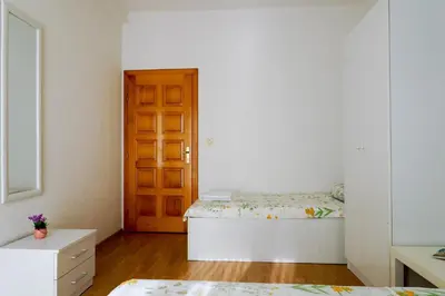 a bedroom with a bed and a wooden door at Guest House Heart of Budva in Budva