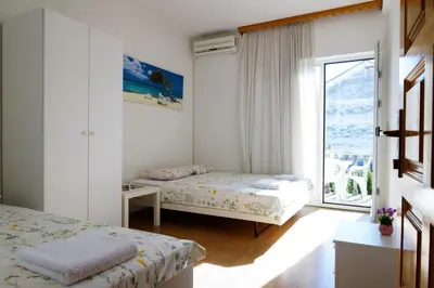 a bedroom with two beds and a large window at Guest House Heart of Budva in Budva