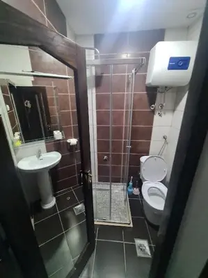 a bathroom with a shower and a toilet and a sink at Malibu Apartments in Sutomore