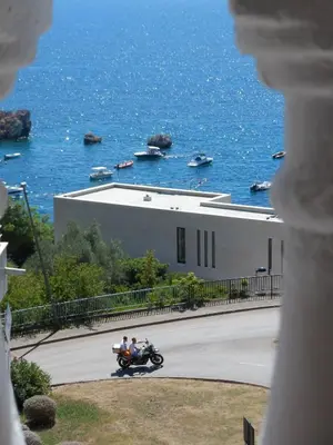 two people riding a motorcycle on a road near the water at Milocer Apartment in Sveti Stefan