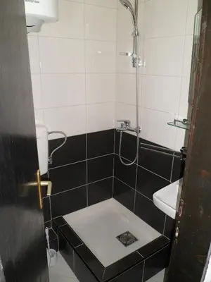 a small bathroom with a shower and a sink at Milocer Apartment in Sveti Stefan