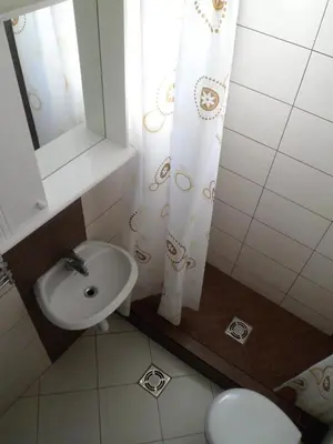 a bathroom with a sink and a shower curtain at Milocer Apartment in Sveti Stefan