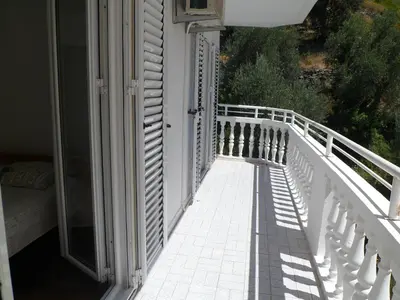 a balcony of a house with a white railing at Milocer Apartment in Sveti Stefan