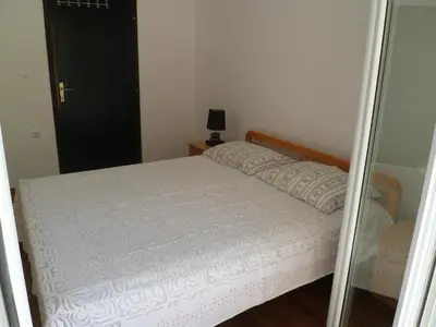 a bedroom with a bed and a mirror at Milocer Apartment in Sveti Stefan