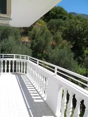 a white balcony with a white railing and trees at Milocer Apartment in Sveti Stefan